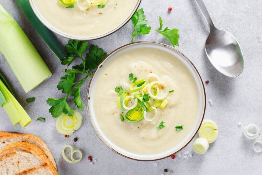 Sopa de alho-poró e batata em cumbuca em cima de uma superfície lisa