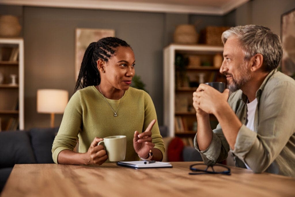 Casal sentado à mesa tomando café