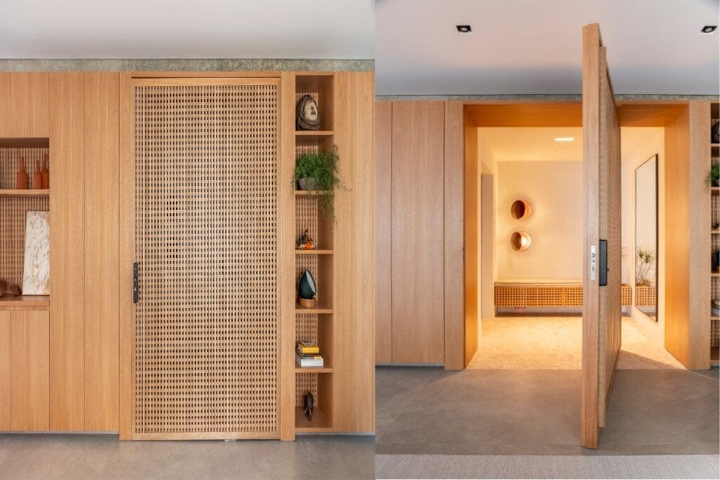 Painel de madeira com porta muxarabi em destaque, integrando-se a prateleiras decorativas e ambiente interno iluminado