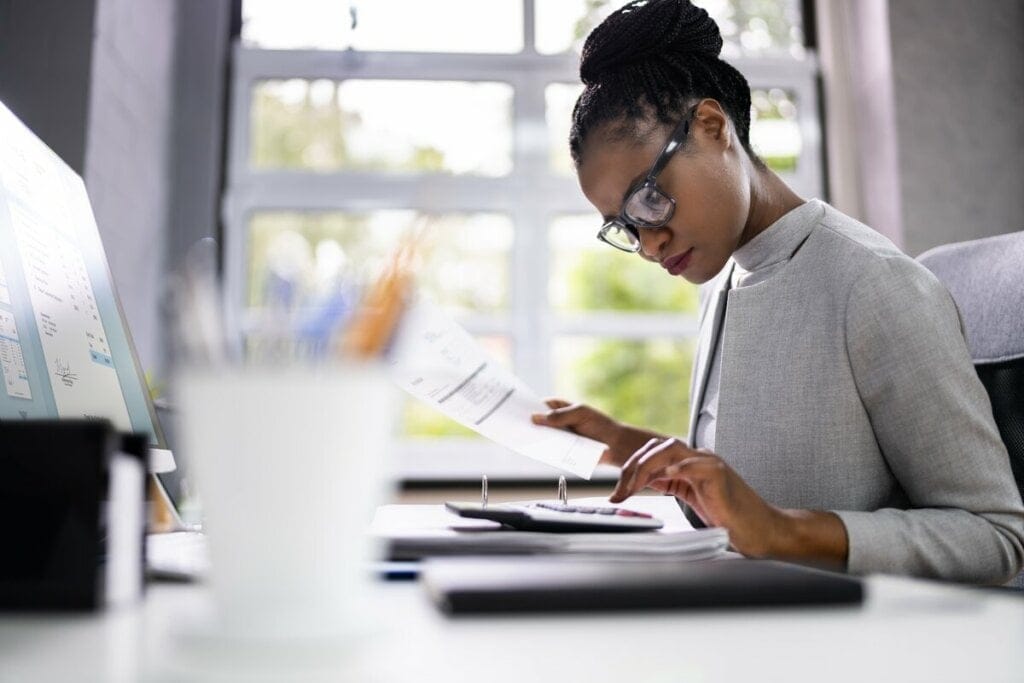 Mulher usando óculos sentada mexendo em um tablet
