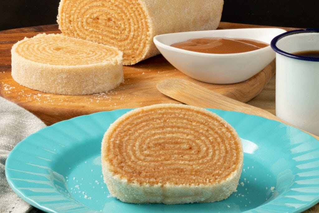 Fatia de bolo de rolo em prato azul