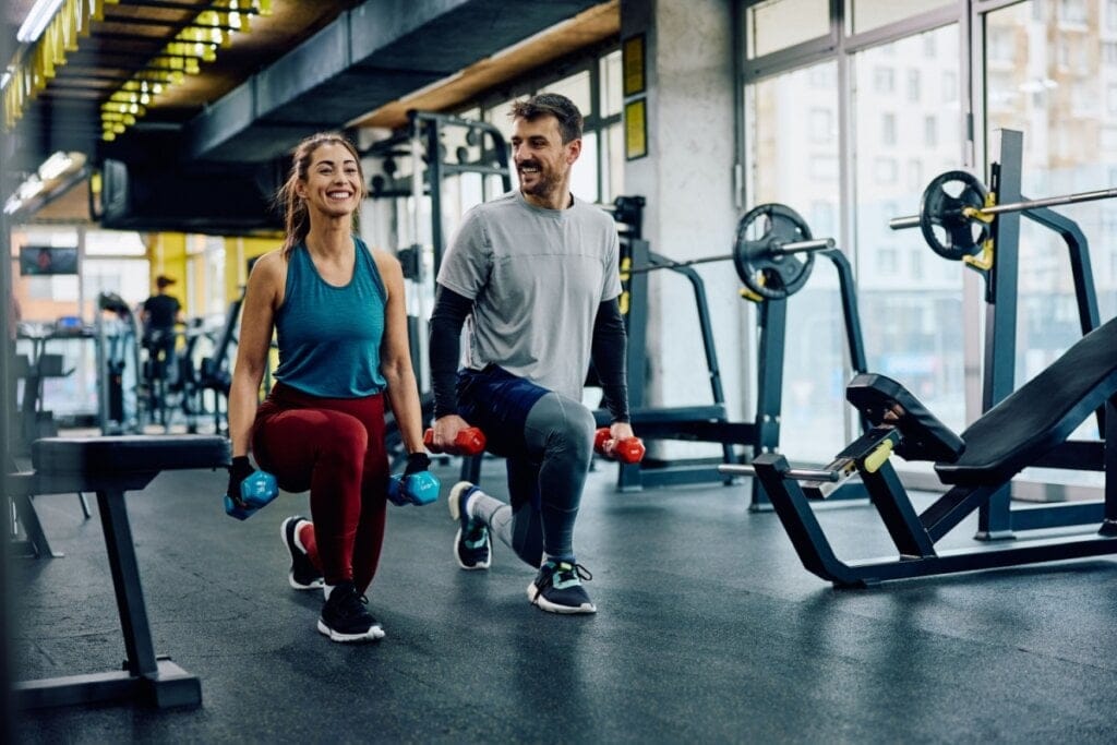 Casal praticando exercício juntos na academia