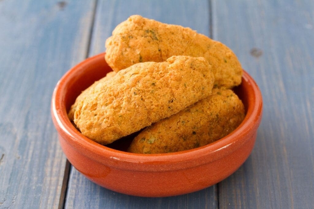 Croquetes fritos empilhados em recipiente marrom 