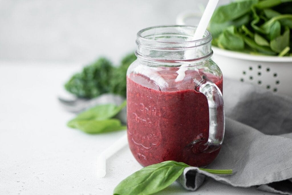 Caneca de vidro com suco de uva com chia e folhas de espinafre
