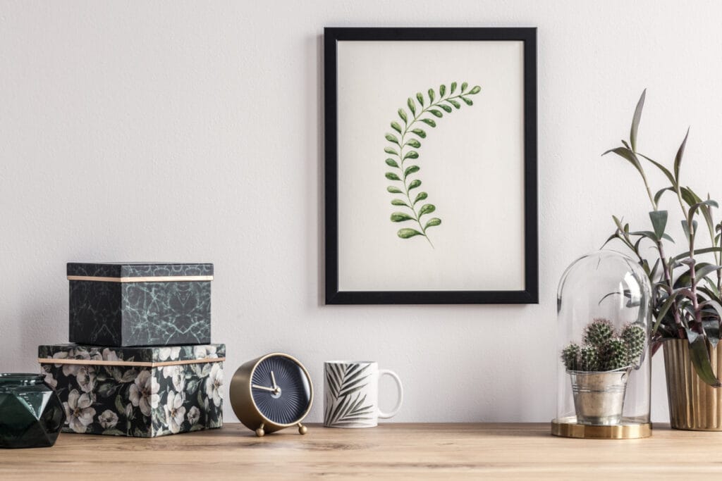 Decoração de mesa com relógio, planta e um quadro de planta