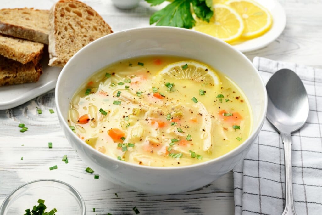 Recipiente banco com sopa de frango com limão, legumes e orzo 