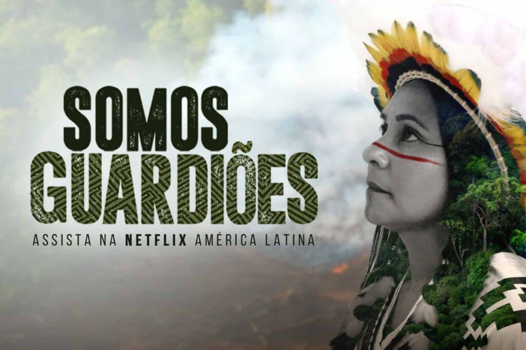 Capa do filme-documentário "Somos Guardiões" com a foto de uma mulher indígena sobre a imagem de uma floresta sendo devastada 