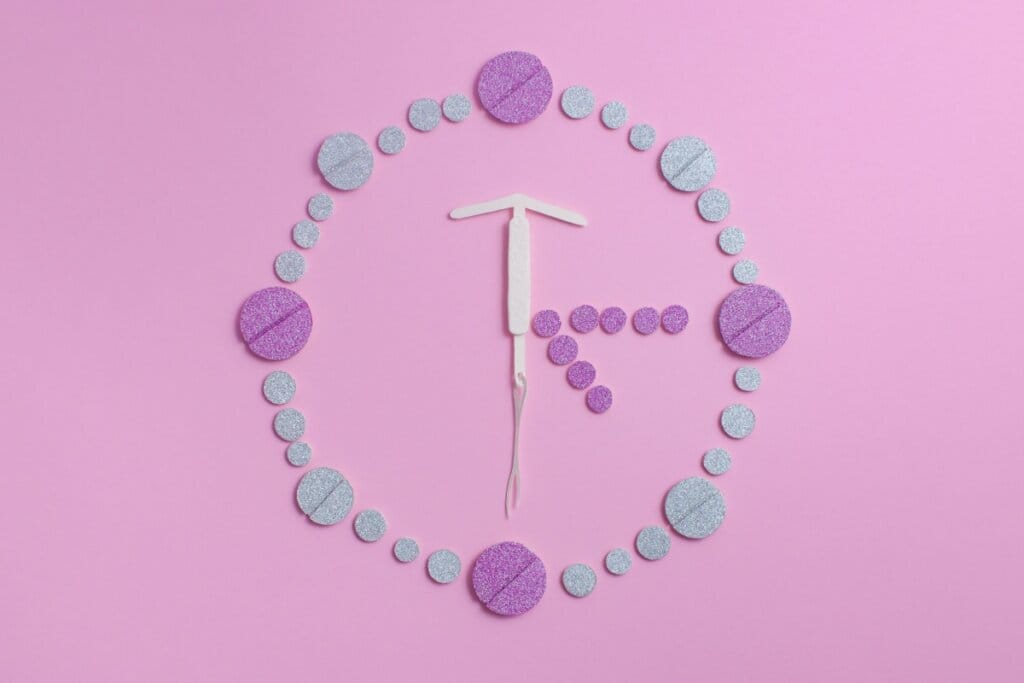 Imagem com comprimidos montando um relógio com um DIU no meio  