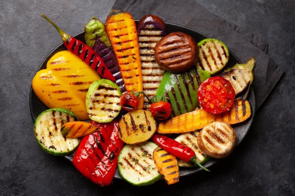 Salada de legumes grelhados em uma travessa preta 
