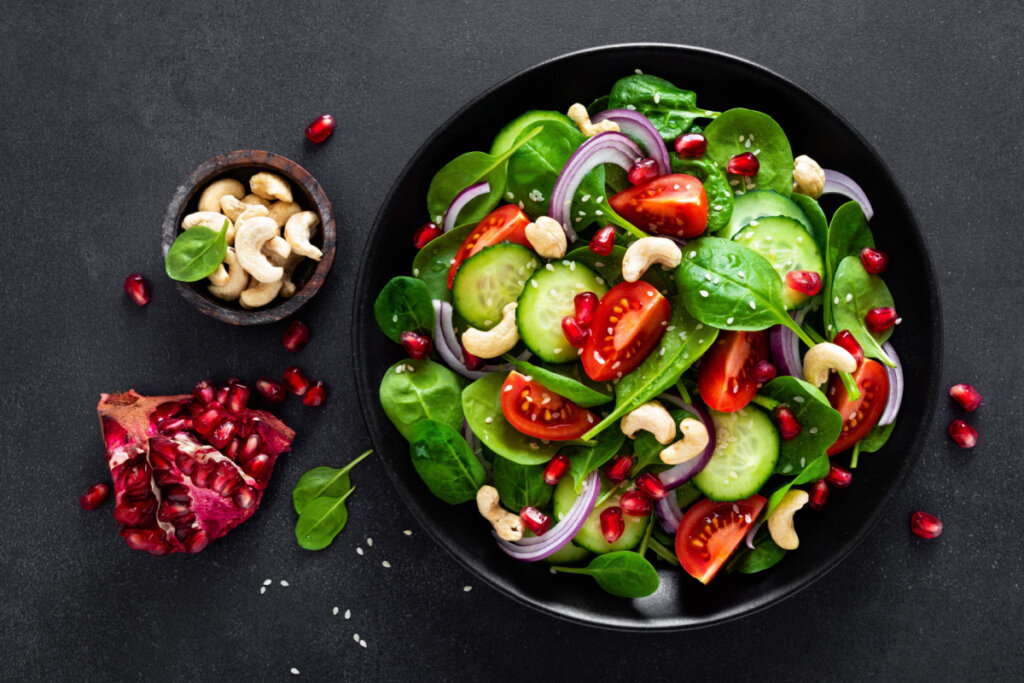 Salada de espinafre, tomate, pepino e cebola-roxa em pote preto