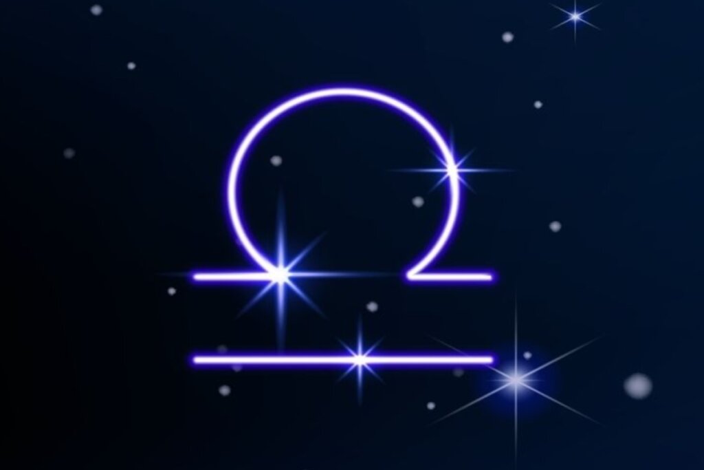 Símbolo do signo de Libra em roxo em fundo azul-escuro com pontos de luz simbolizando as estrelas