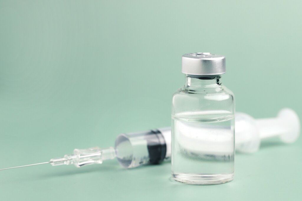 Frasco de vacina em um fundo verde-claro