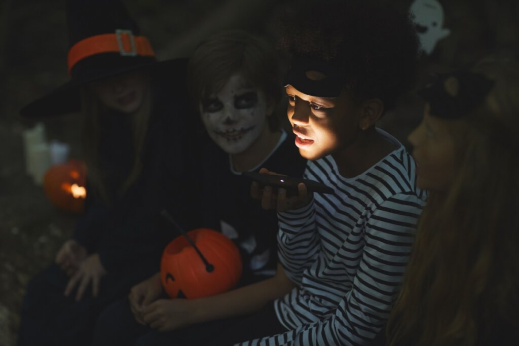 Crianças usando fantasias de Halloween contando histórias