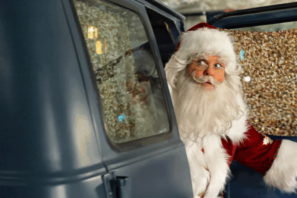 Papai Noel olhando para fora de uma van aberta