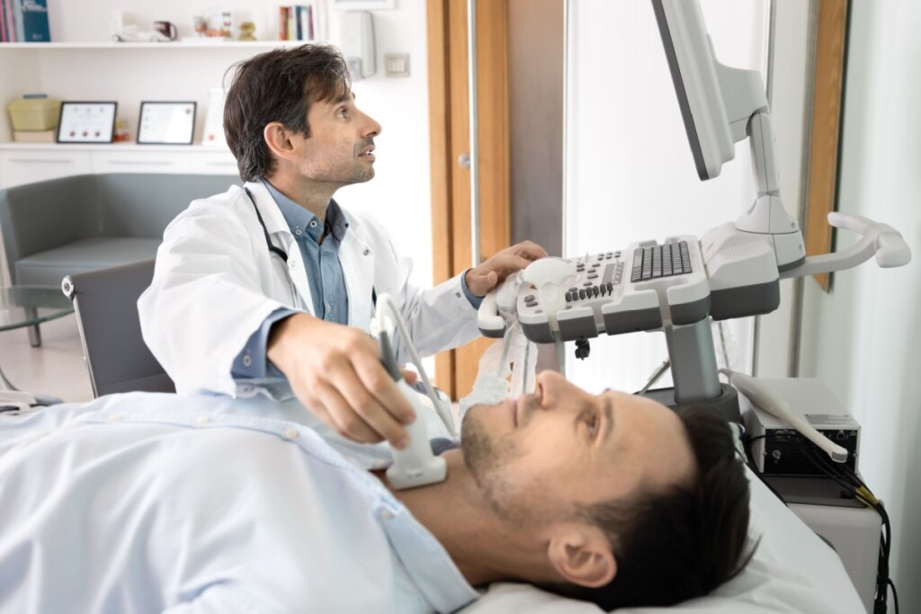 Médico realizando ultrassonografia da tireoide em paciente deitado