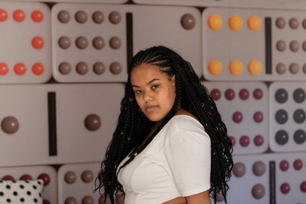 Mulher com cabelos trançados e soltos, usando blusa clara