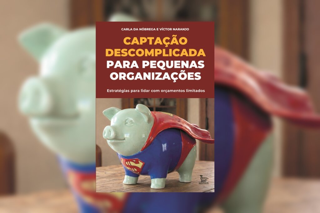Capa dividida: a metade superior é marrom com o título em branco; a inferior mostra a foto de um cofrinho de porco verde claro usando o traje e a capa do Superman.