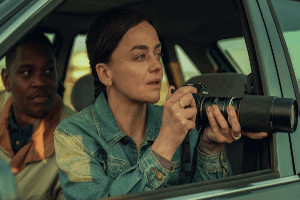 Cena da série "Personas" com agente fotografando em um carro enquanto colega observa ao fundo