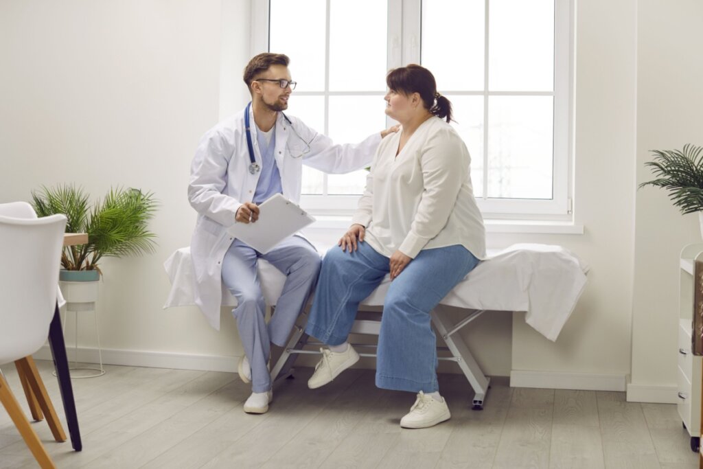 Médico segurando ombro de paciente obesa