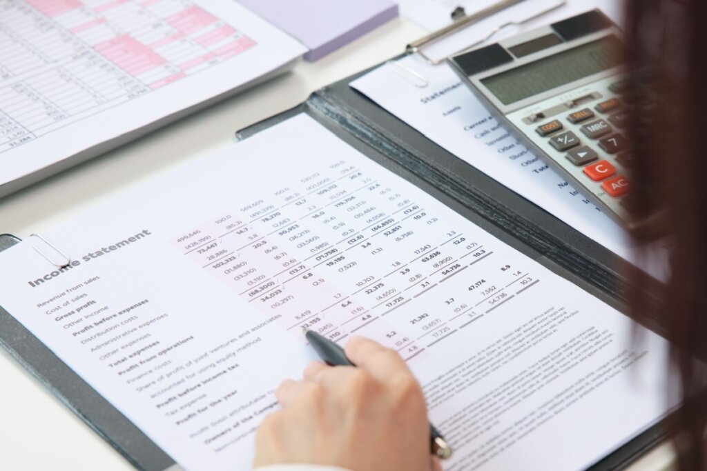 Mão segurando uma caneta sobre um extrato bancário