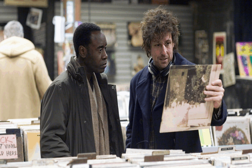 Dois homens escolhendo discos em loja de discos, usando roupas de frio em tons escuros 