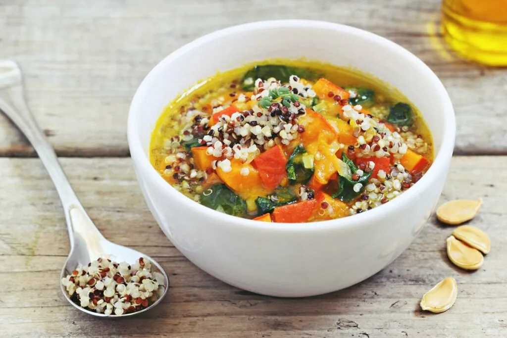 Recipiente branco com sopa de abóbora e lentilha