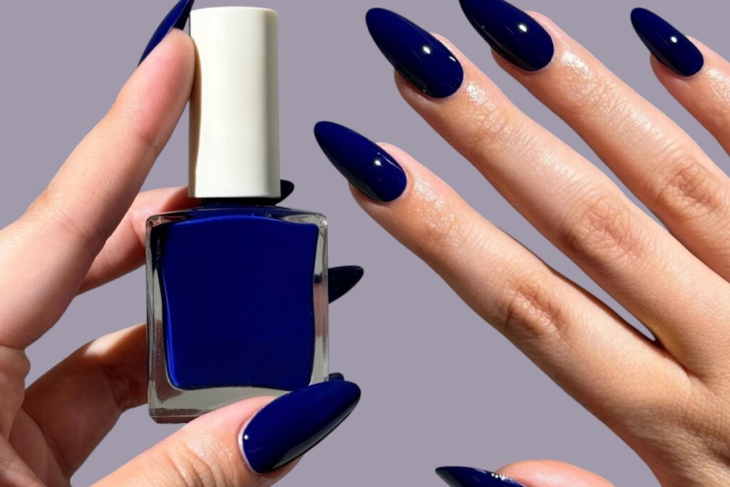Mãos com unhas longas pintadas com esmalte azul-marinho