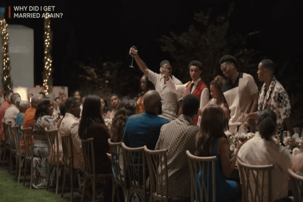 Cena de Why Did I Get Married Again?: convidados sentados a uma longa mesa de jantar ao ar livre à noite enquanto um homem de pé ergue a taça em brinde