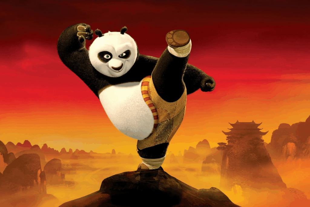 O panda Po fazendo uma pose de arte marcial e se equilibrando em uma só perna no topo de uma rocha. O fundo traz tons alaranjados de pôr do sol com silhuetas de montanhas e uma construção no estilo chinês tradicional
