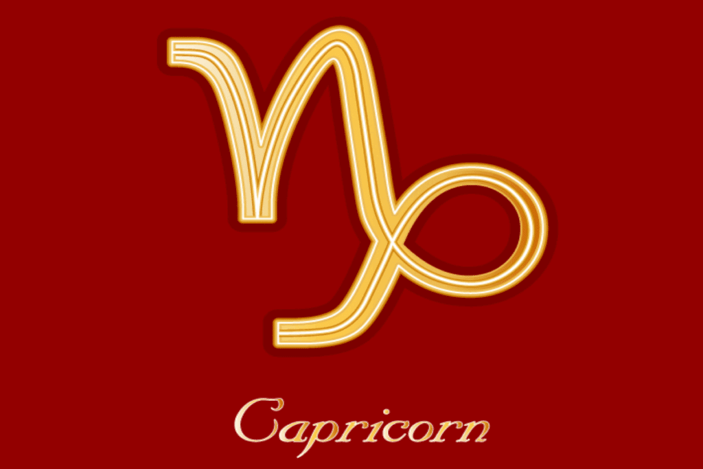 Ilustração do símbolo astrológico do signo de Capricórnio em dourado, com contornos brilhantes, sobre um fundo vermelho-escuro. Na parte inferior, aparece a palavra “Capricorn”, escrita em letras douradas e cursivas.